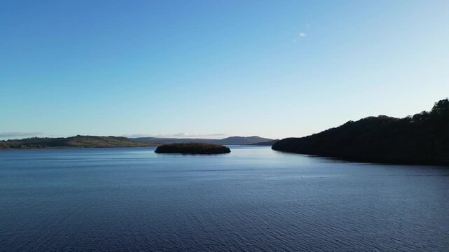 Aerial View of Calm Water of Massive Lake at Balmaha Valley Village Near Glasgow Landscape During Sunset. Village is a popular tourist destination for picnickers and day trippers from Glasgow