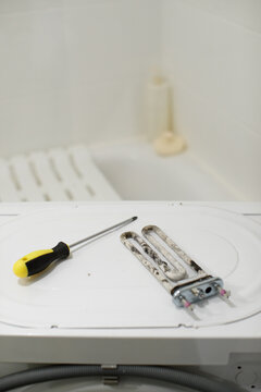 Washing machine heating element repair showing limescale buildup