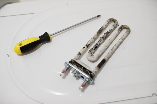 Washing machine heating element showing scale and damage