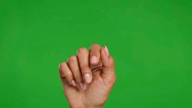 Female hand forming a closed fist, ready for diverse graphic compositions on a vibrant green background