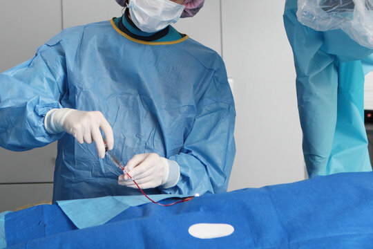 Surgery on blood vessels. Removal of blood clots. The patient is under general anesthesia. Surgeons' hands. Prevention of blood clots. Modern medicine.