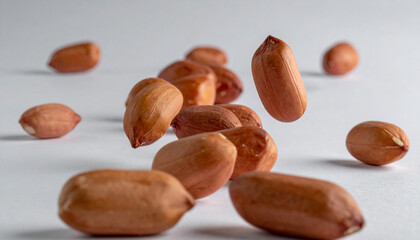 Obraz premium Close-up of shelled peanuts in motion against a neutral gray backdrop