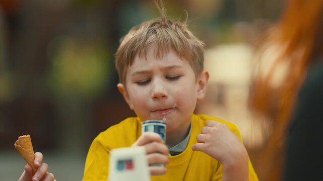 Young blond boy drinking yogurt and making funny faces