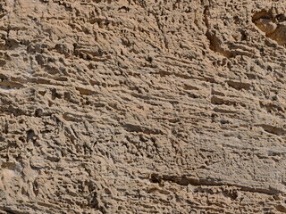 Naklejka premium Weathered limestone surface with irregular structure and natural color contrasts on the rocky coast of Mallorca. Close-up. Copyspace.