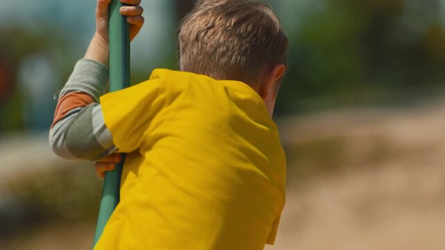 Happy young boy riding a zip line at the playground