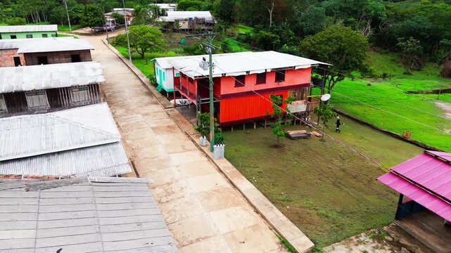 High angle aerial view of a small rural settlement and residential house with corrugated metal roof in the Amazon region Brazil
