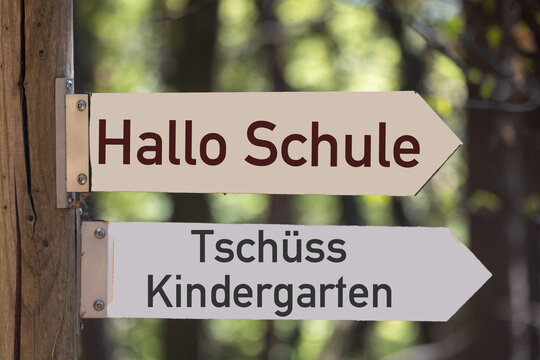 Schilder im Wald mit hinzugef&uuml;gtem Text HALLO SCHULE und TSCH&Uuml;SS KINDERGARTEN