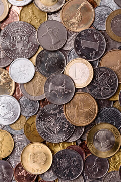 A background of silver, gold, and copper coins of various denominations. Metal coins