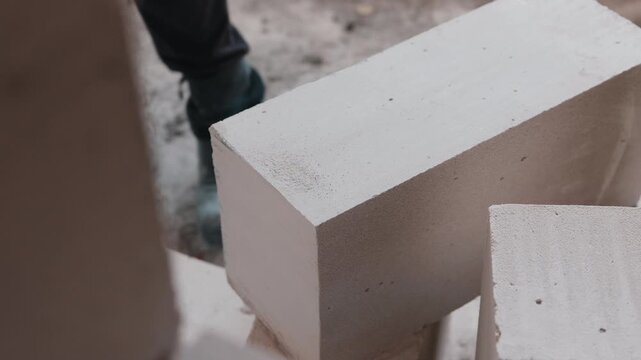 Worker moving aerated concrete block during construction