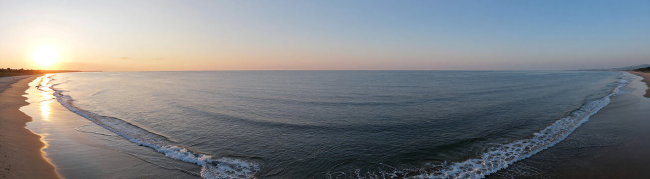 aerial photograph captures serene ocean scene low tide gentle waves lapping shore beneath warm golden