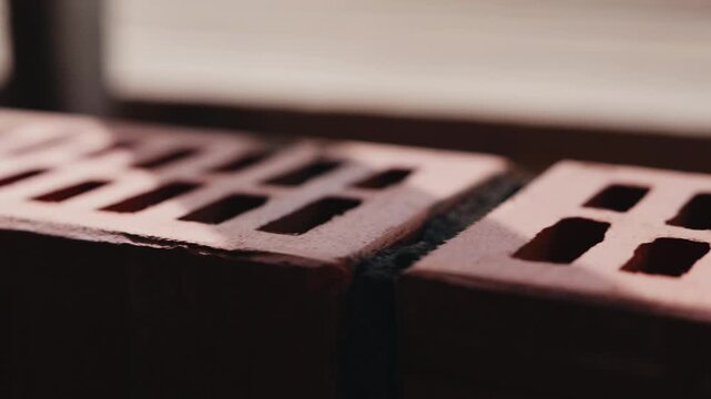 Camera movement along brick wall surface during masonry construction close up