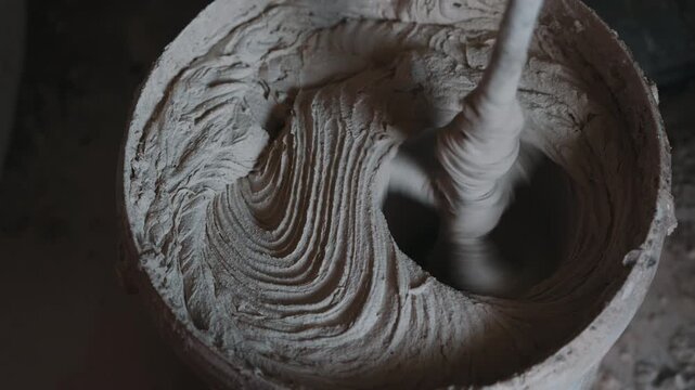 Mixing cement mortar in bucket with electric mixer close up