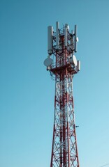 Naklejka premium Telecommunication tower with multiple antennas against clear blue sky. Steel structure for wireless signal transmission broadcasting network. Modern tech equipment for cellular phone service.