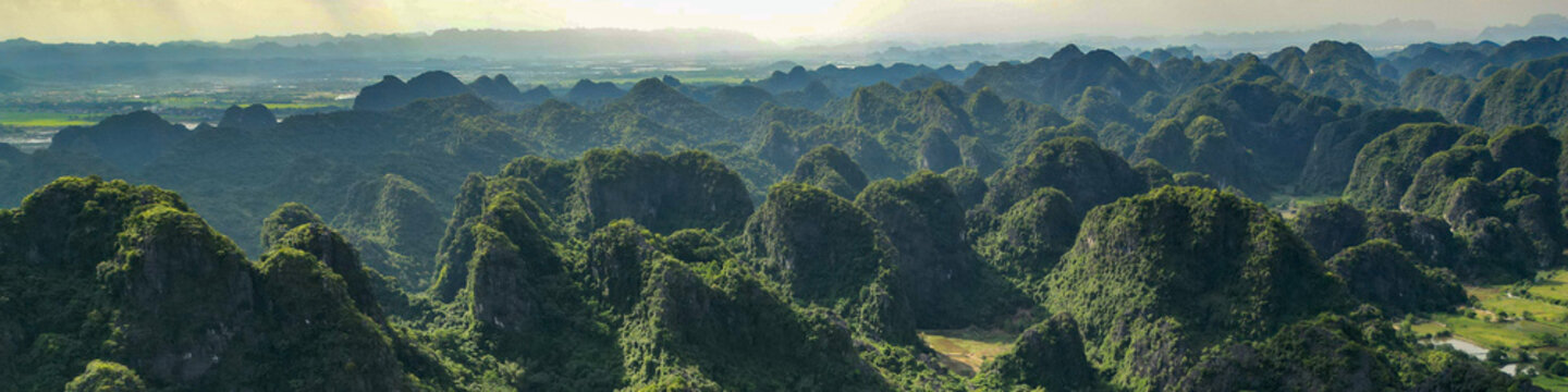 Aerial of dramatic Ninh Binh karst mountains, professional LinkedIn banner for tourism and conservation industry.
