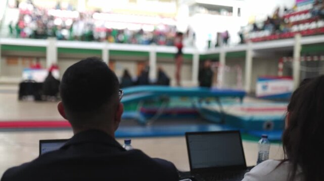 Gymnastics judges scoring trampoline competition performance