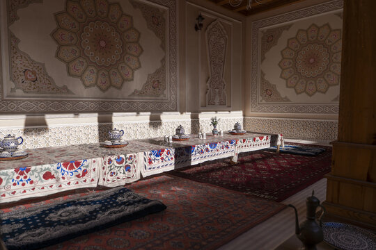 View of traditional Uzbek dining room with low tables, embroidered tablecloths, and intricate wall patterns Tashkent, Uzbekistan.