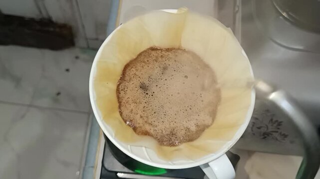 used coffee filter in a white ceramic pour-over dripper