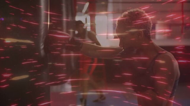 Woman shifting weight and punching heavy bag in gym, training, red streak overlay showing bag swing