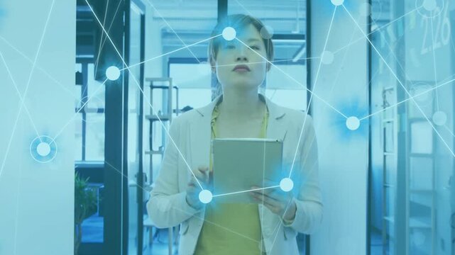 Female pro entering corridor, tapping tablet, generating network overlay, reviewing business data