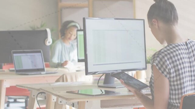 Frame shifting revealing teenager writing as woman tapping tablet and checking sheet for business