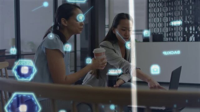Woman using laptop and pointing, coworker leaning with cup, AR linking to laptop for business demo
