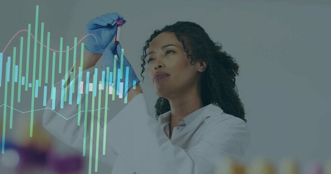 Examining scientist in white coat, blue gloves holding purple cap tube at lab bench, with graphs