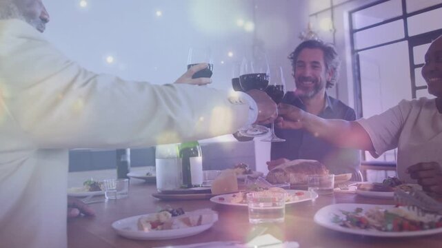 Left hand reaching starting toast, four diners toasting, celebrating, bokeh shimmering over glasses