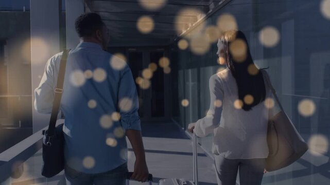 Couple walking airport bridge toward gate, bokeh overlay drifting, obscuring them and suitcases