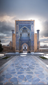 View of the ornate blue tiled entrance portal and geometric courtyard under a cloudy sky in Samarkand, Samarqand Region, Uzbekistan.
