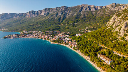 Obraz premium Aerial view of the beautiful coastal town of Gradac on the Makarska Riviera in Croatia featuring turquoise Adriatic Sea pebble beaches and the Biokovo mountain range