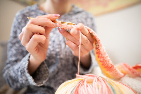 かぎ針編みでハンドメイド作品を作る女性の手元と毛糸の接写