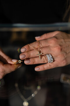 Customer holding diamond ring in hand while examining jewelry details before purchase.