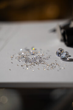 Diamond evaluation with loose gemstones arranged near grading chart.