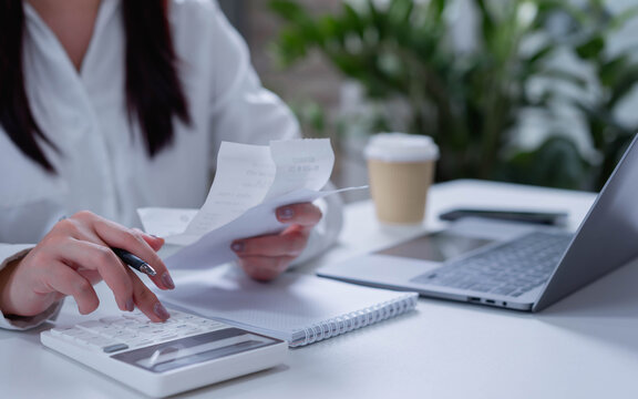 Businesswoman using calculator for tax and financial management, invoice and money accounting, budgeting, expense tracking and business finance concept.