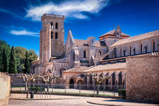Ancient monastery complex showcasing romanesque and gothic architecture under a clear blue sky