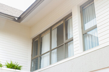 Fototapeta premium Modern house exterior with casement window and white wall rendering,Large estate minimal home building Window Frame,Cozy home in nature.