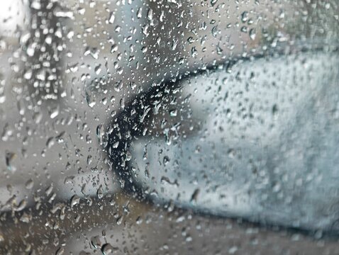 Basra, Iraq - April 24, 2026: Raindrops on car window under a large bridge during storm