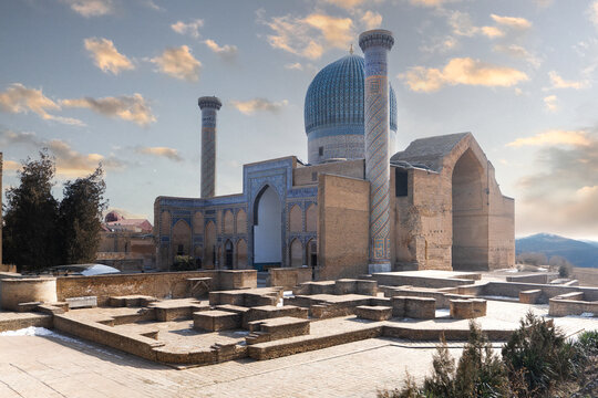 View of the Gur-e-Amir mausoleum with its iconic blue dome and minarets under a soft sunset sky in Samarkand, Samarqand Region, Uzbekistan.