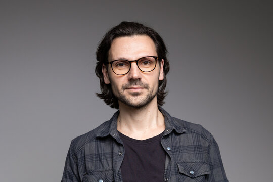 Smart professional man in glasses and plaid shirt with slight smile