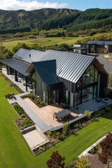 Obraz premium A contemporary house is beautifully situated in a picturesque countryside, surrounded by lush green fields and majestic mountains, all beneath a clear blue sky in New Zealand