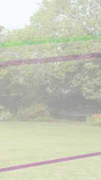 Vertical video: Frames shifting tilting up revealing lawn trees beds trampoline color bands moving