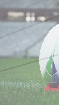 Vertical video: Camera panning right, soccer ball slowly revealing on red tee preparing for kickoff