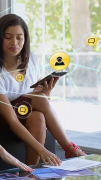 Vertical video: Marketer using tablet and reading charts, sparking yellow chat nodes to map clients