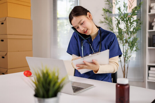 Female medical professional multitasking on phone call taking notes