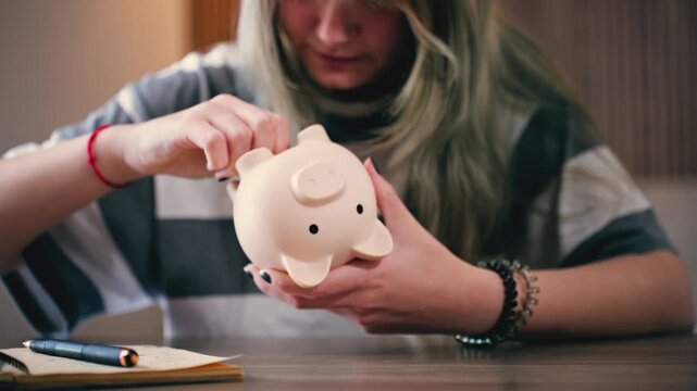 Teen girl taking money from piggy bank for education, saving for study, financial planning, student expenses and future investment concept.