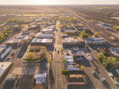 Holbrook, United States - 05 April 2026: Aerial view of the historic town center with long straight roads, low-rise buildings, and the surrounding desert landscape under golden hour light.