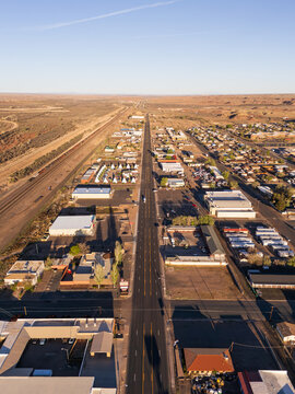 Holbrook, United States - 05 April 2026: Aerial view of the historic town of Holbrook featuring the Wigwam Motel, straight desert roads, and railway tracks under a clear sky.