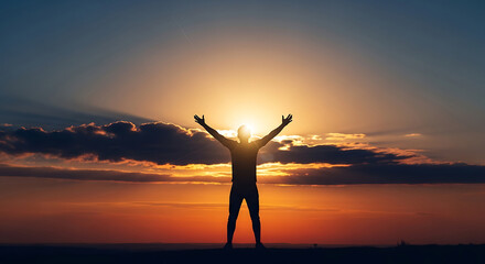 Fototapeta premium Man standing with arms raised during a beautiful sunset