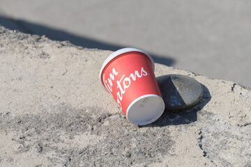 Obraz premium discarded Tim Hortons beverage cup on a concrete block outdoors, Toronto