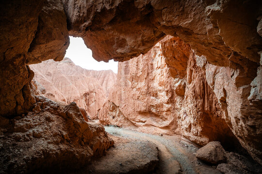 Cave entrance scenery in Huoyun Valley Canyon, unique Danxia landform cliffs and rocky gorge, Turpan, Xinjiang